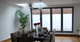 A 4 door bi fold in grey gives this dining area a light and airy appearance
